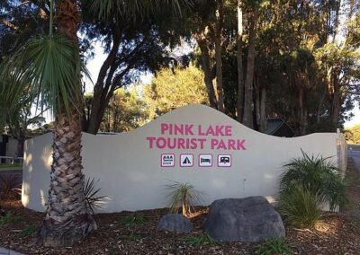 A pink lake tourist Park sign at the stone welcome area